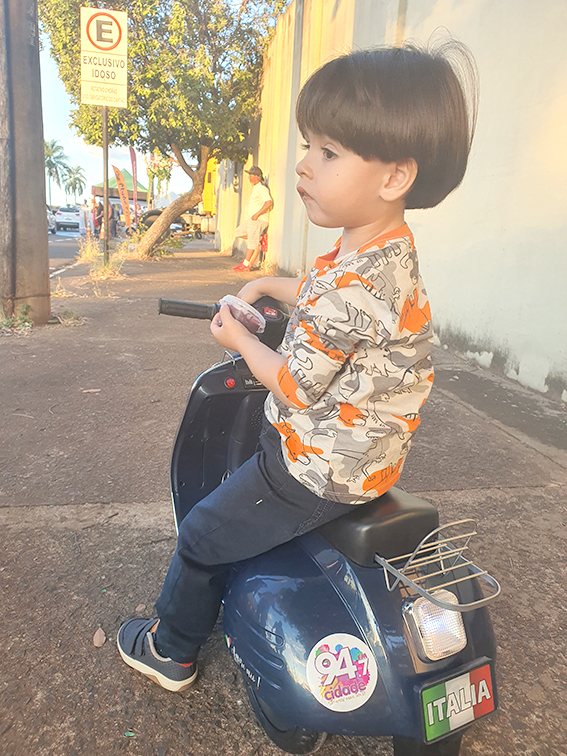 O garotinho Gael Carmona da Silva Ferraz, todo estiloso em sua lambreta elétrica, passeando na carreata de São Cristóvão com seu avô Vilmar da Farmácia. Gael passou por nossa equipe que fazia a cobertura do evento e pediu um adesivo da Rádio Cidade 94,7 FM. Pedido feito e realizado, ele ficou todo feliz com o adesivo e nós amamos esse momento em que o fofurômetro explodiu