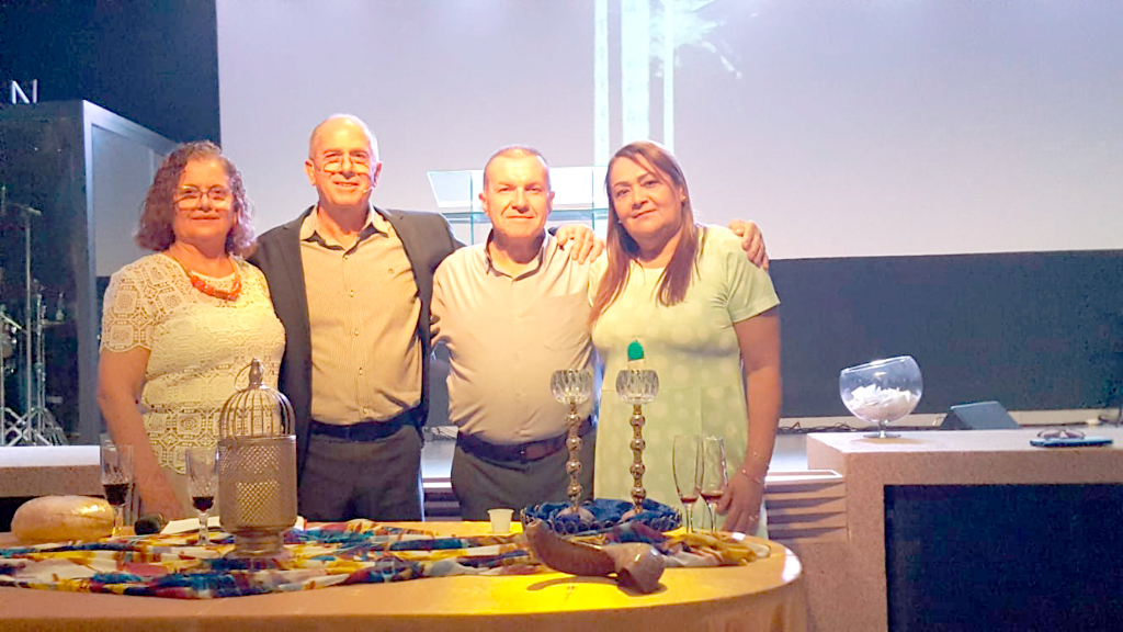 O último domingo foi de união e comunhão para os Apóstolos Saul e Edson que se uniram, para celebrarem juntos a santa ceia do Senhor. Juntas, as igrejas SHEKINAH, liderada pelo apóstolo Saul e a IAPG – Igreja Apostólica Profética da Graça, liderada pelo apóstolo Edson participaram da comunhão onde compartilharam do corpo e do sangue de Cristo unidos em amor, assim como Jesus nos ensinou. Na foto o apóstolo Saul e sua esposa a bispa Lucinei e o apóstolo Edson com sua esposa, a pastora Fran 