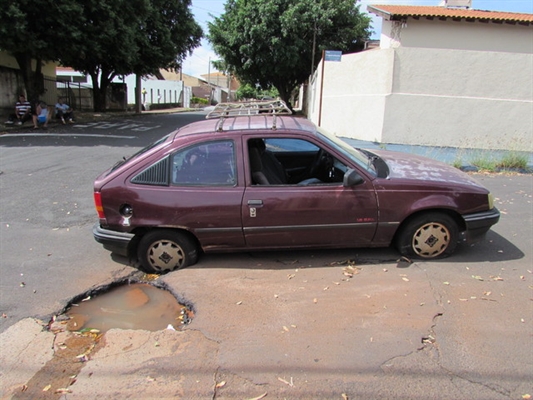 Buraco em rua estoura pneu e causa  estrago no reservatório de óleo do carro