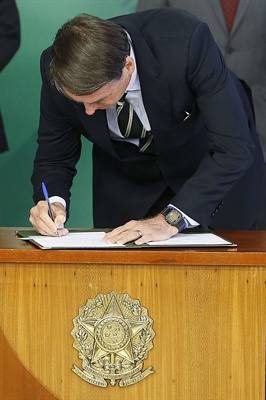 O presidente Jair Bolsonaro (PSL) assina o decreto da flexibilização de compra de arma de fogo e munição no País (Foto: Dida Sampaio / Estadão)
