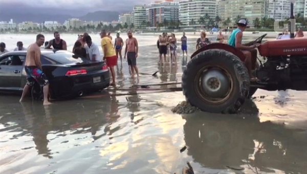  Banhistas tentaram ajudar motorista que atolou na praia (Foto: Reprodução/Aconteceu em Bertioga) 