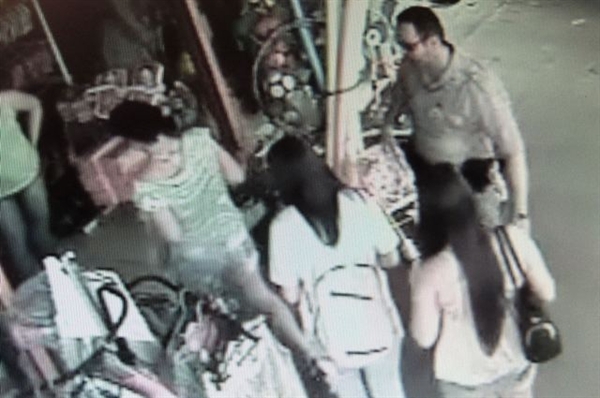 Imagem mostra momento em que policial militar aborda as suspeitas em frente da loja