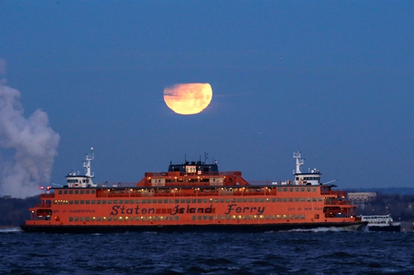  'Superlua azul de sangue', que aconteceu em janeiro deste ano é vista parcialmente eclipsada sobre a balsa de Staten Island vista do Brooklyn, em Nova York, nos EUA (Foto: Eduardo Muñoz/Reuters) 