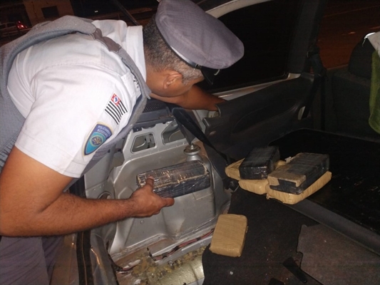 Policial retira drogas escondidas na lataria do veículo em Nova Independência — Foto: Divulgação/Polícia
