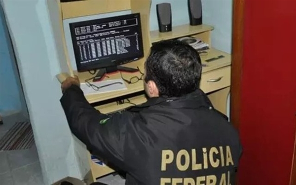Policial Federal analisa computador apreendido (Foto: Divulgação/Polícia Federal)