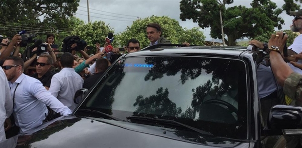 Bolsonaro coloca parte do corpo para fora da janela do carro para acenar para eleitores ao deixar escola em que votou na zona oeste do Rio (Foto: Cristina Boeckel, G1)
