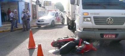 Motocicleta vai parar embaixo de caminhão após colisão