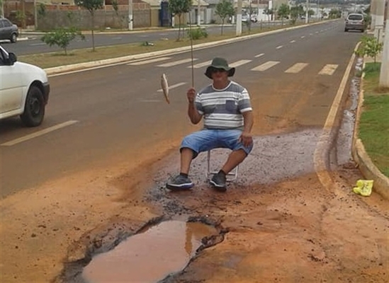 Moradores chegaram a “pescar” em um buraco do bairro para protestar contra os problemas estruturais (Foto: Arquivo pessoal)