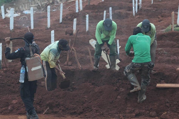 Pessoas que foram pegas sem usar máscara na Indonésia foram forçadas a cavar túmulos. (Foto: Rex Features)