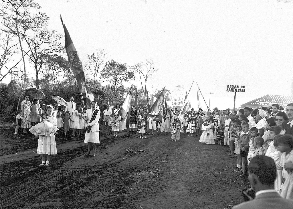 Leia na placa “obras da Santa Casa” e o desfile das colônias imigrantes construindo a cidade