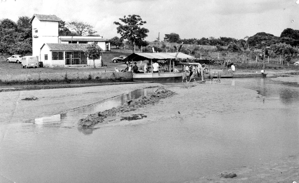 A represa da Saev no ano de 1966. Vê-se ao fundo a antiga Casa de Máquinas, construída na administração do prefeito João Gonçalves Leite. Aparece na foto, estacionada à margem da represa, a Draga adquirida pelo governo de  Dalvo Guedes para as obras de desassoreamento (aprofundar a represa e tirar os bancos de areia), visando aumentar o volume de água. A Saev se manteve forte graça à atenção recebida de todos os prefeitos.