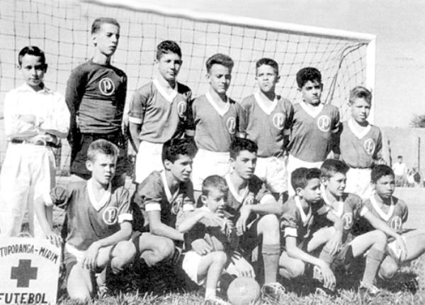 Campeonato Mirim -58 - 1958- O Campeonato Mirim de Futebol era a sensação em Votuporanga. O certame era organizado pelo saudoso sargento Atilano Guatemozim Pedroso. Na foto o time do Palmeiras. A partir da esquerda, de pé: Oscar Silvério Gomes (massagista), Julinho Barbieri (goleiro), Dorinha, Joãozinho, Paulo Sérgio de Oliveira, Rui Marão, e Humberto Bonetti Júnior (Betinha). Agachados: Haroldinho Mazaferro, Ney Neves, Juninho Barbieri (mascote), Zuza, Zequinha Neves, Reinaldinho, e Índio. Nota do colaborador Dago :” Esta foto foi publicada na revista Expressão/edição Nov. 1997. O documento fotográfico pertencia aos irmãos José Orestes e Antonio Grogia Júnior. Hoje a foto é do arquivo pessoal de Carlito Carreteiro.”