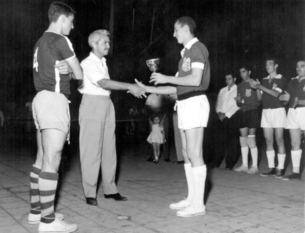 TAÇA RÁDIO PIRATININGA - Ano 1960. - As lentes do competente fotógrafo Takeo Sato (Foto Sato - Rua Amazonas, 962 - telefone 45) captaram esta imagem no encerramento do Campeonato de Futebol de Salão, na quadra do Votuporanga Clube. O timaço do Induscômio (Banco do Comércio e Indústria) conquistou o título de campeão e recebeu a “Taça Rádio Piratininga” de Votuporanga.Aparecem na foto da esquerda para a direita: Rui Marão (só observa é vice-campeão), o historiador e radialista Edward Coruripe Costa (Costa Júnior), Antonio José Viscardi (capitão do time do Induscômio), Luizinho Algarve, Édison Cóculo Martins (Baiano) e Francisco Melchior Baffi. A foto pertence ao arquivo pessoal do atleta Rui Marão.