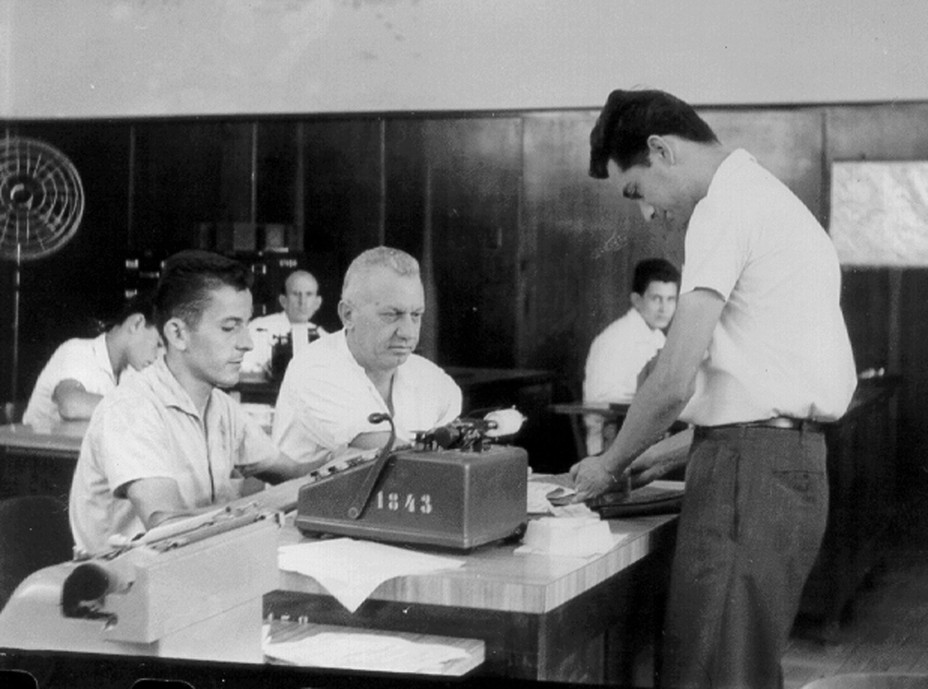 Quando ninguém poderia imaginar a chegada das urnas eletrônicas, os votos eram contados pela junta apuradora nomeada pela Justi ça Eleitoral. Esta foto é de 1957 e apresenta os componentes de uma mesa: Jaime de Bortole, prof. Floriano Marzochi, Ador de Almeida, Luiz Arthur Barizon e Alcides de Oliveira Filho. Observe, na mesa, a velha máquina de somar.