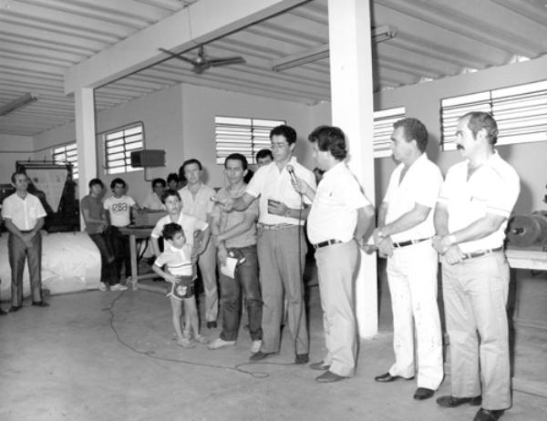 As bençãos do Pe. Silvio - O Padre Silvio Roberto dos Santos foi quem procedeu as bençãos religiosas das nossas instalações na tarde de 31 de dezembro de 1984. Aparecem na foto, a partir da esquerda: Osório Casado, Valter Peresi, radialista Júlio Júnior, Pe. Silvio e João Carlos Ferreira, o idealizador do projeto jornalista Luiz Rivoiro e o diretor de escola prof. Uélinton Garcia Peres.