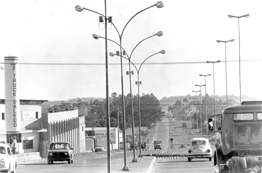 A conhecida avenida do Pozzobon (Emilio Arroyo Hernandes) hoje disputada por lojas de todo tipo de comércio, foi aberta nos anos 70, com a implantação do primeiro Distrito Industrial. Nesta foto dos anos 80 dá para a gente avaliar o quanto cresceu aquele setor da cidade. A foto mostra a fachada da indústria Truck Galego e as luminárias instaladas na época. Hoje aquele local é um dos “cartões postais” símbolo do progresso da cidade.
